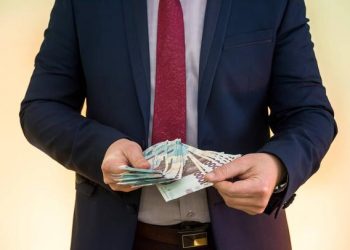 man in suit counts profits. men's hands convert hryvnia. 1000 new banknotes, Ukrainian money